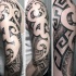 Unusual black and white shoulder tattoo on various tribal ornaments