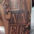 Unusual black ink big cubes with letters tattoo on shoulder stylized with hearts