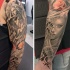 Ungewöhnliche Kombination schwarzweiße Engelstatue und dämonische Frau Porträt Tattoo mit farbigen Wildblumen