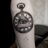 Tatuaje en el antebrazo, reloj retro y ojo de la providencia