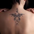 Tatuaje en la espalda, mariposa estilizada y jeroglíficos, tinta negra