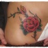 Tatuaje  en la cintura, rosa con tallo con espinas