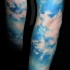 Tatuaje en el brazo, cielo azul fascinante