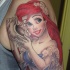 Very beautiful looking colored shoulder tattoo of cartoon mermaid Ariel with shell