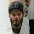 Very detailed arm tattoo of smiling man portrait