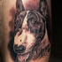 Very detailed realism style colored dog with lettering tattoo