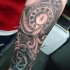Tatuaje en el antebrazo, reloj hermoso con pluma blanca y rosa
