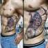 Tatuaje en el costado, parte de reloj viejo grande