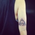 Vintage black ink arm tattoo of triangle stylized with wild flower