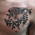 Vintage picture style colored chest tattoo of fantasy animal with wings and tree branch