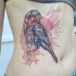 Tatuaje de ave estilizado con manchas de pintura