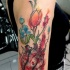 Watercolor style detailed shoulder tattoo of breathtaking flowers with human heart
