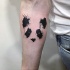 Watercolor style interesting looking forearm tattoo of panda bear face