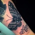 Tatuaje en el antebrazo,
polilla negra y gris con nombre