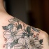 Tatuaje  de flores blancas en el hombro