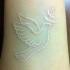 Tatuaje en la muñeca,
paloma de la paz, tinta blanca