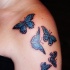 bianca con blu piccole farfalle tatuaggio su spalla