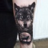 Tatuaje en el antebrazo,
cara de lobo y silueta de lobo que aulla a la luna