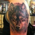 Tatuaggio colorato sul deltoide la faccia del lupo