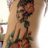 donna con fiori ibisco tatuaggio sulle costolette