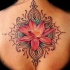 Tatuaje en la espalda, loto de color rosa apagado