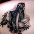bellissima fata seduta tatuaggio