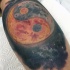 Yin-Yang Symbol in der Form vom großen Planeten Tattoo am Bein