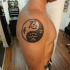Tatuaggio grande sul deltoide il disegno nero in stile Yin-Yang