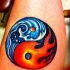 Tatuaggio colorato il fuoco e l'aqua in stile Yin-Yang