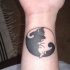 Tatuaje en la mano, yin yang de gatos abrazados