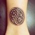 Tatuaggio piccolo sul polso il disegno nero in stile Yin-Yang
