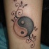Tatuaje en la pierna, yin yang con pequeños rizos