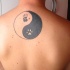 Tatuaje en la espalda, yin yang con huellas