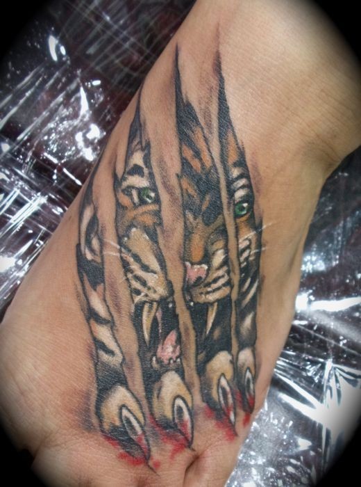 tigre sfugge fuori da sotto pelle tatuaggio su mano