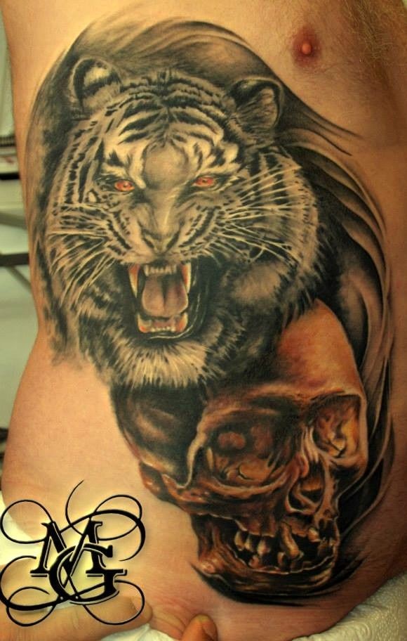 Tiger head and spooky skull tattoo on ribs