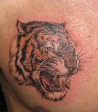 Tattoo mit Tigerkopf an der Brust