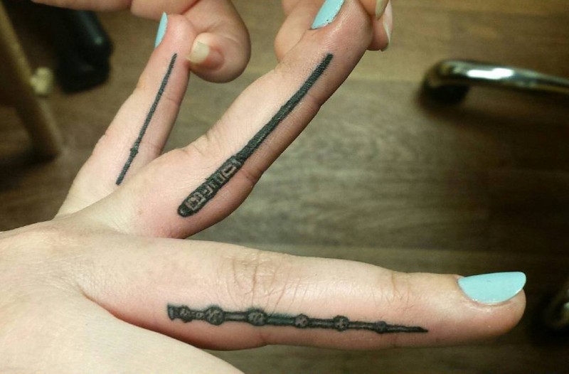 Winzige 3D nette schwarze  verschiedene magische Stäbe Tattoo an den Fingern