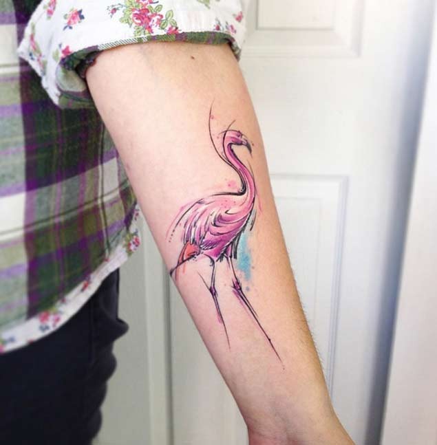 Tiny abstract style colored pink flamingo tattoo on forearm