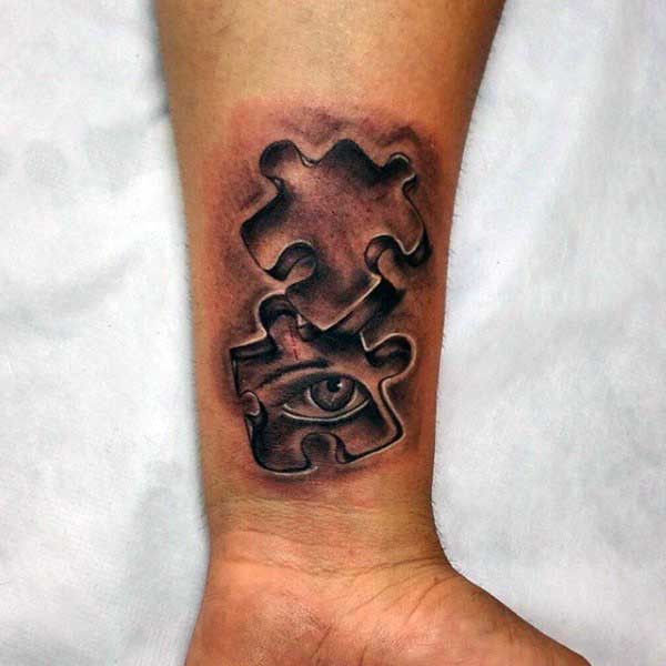 Tiny black and gray style forearm tattoo of puzzle pieces with human eye