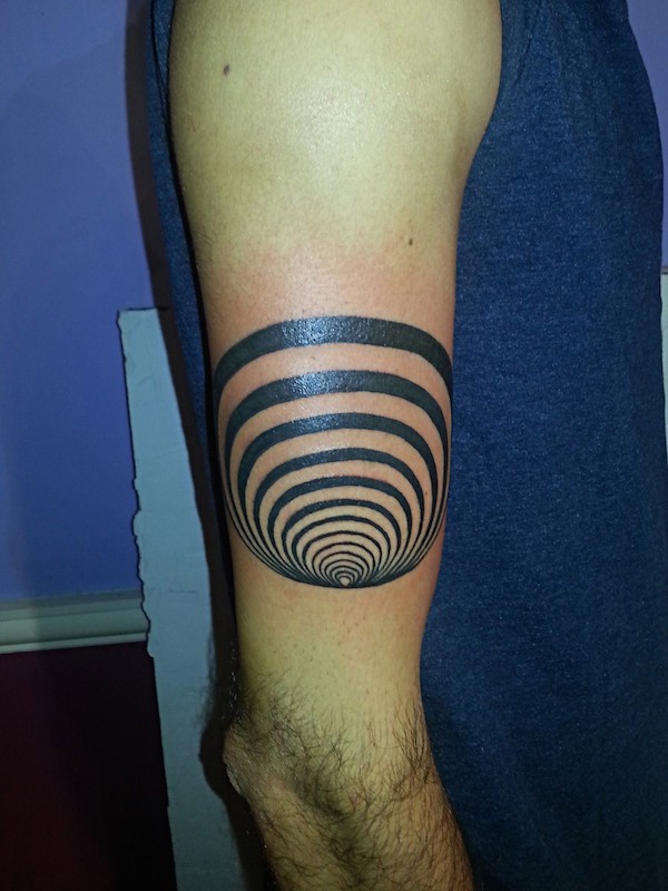 Tiny black ink arm tattoo of hypnotic symbol