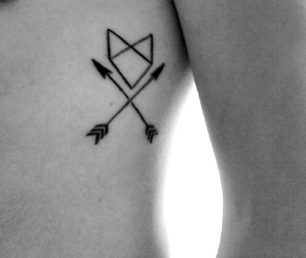 Tiny black ink arrows with lettering tattoo on side