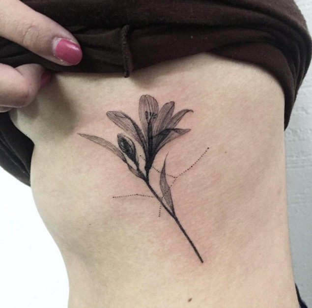 Tiny black ink beautiful flower tattoo on side area