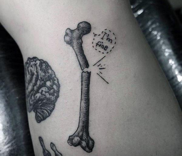 Kleines schwarzes im Gravur Stil gebrochenes Knochen Tattoo mit Schriftzug