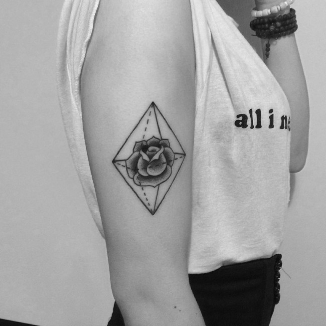 Tiny black ink geometrical figure tattoo on arm with rose