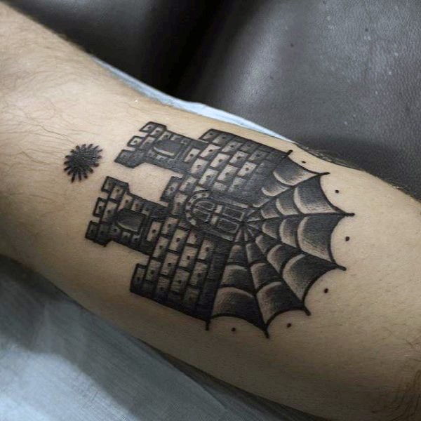 Tiny black ink mystic castle tattoo on arm