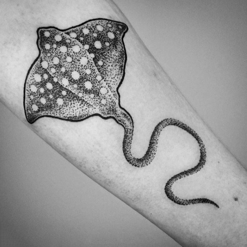 Tiny black ink ray tattoo on forearm with white dots