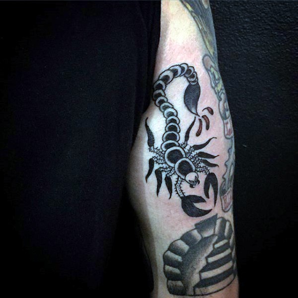 Tiny black ink scorpion tattoo on arm