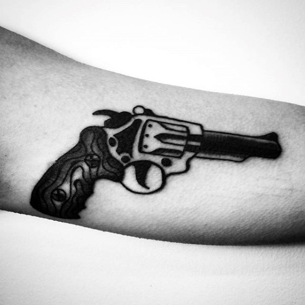 Tiny black ink simple revolver tattoo on arm