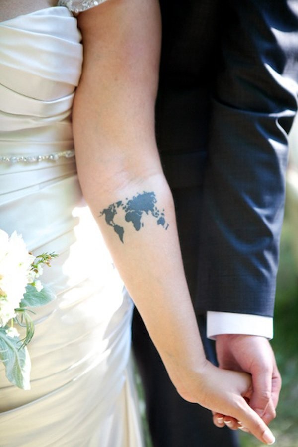 Tiny black ink simple world map tattoo on arm