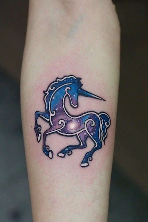 Tiny colored forearm tattoo of fantasy unicorn stylized with space